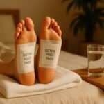 Flat lay photo of detox foot pads with bamboo, herbs, and spa tools on a clean white background.